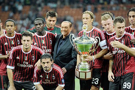 Players of AC Milan and AC Milan chairman Silvio Berlusconi celebrate 