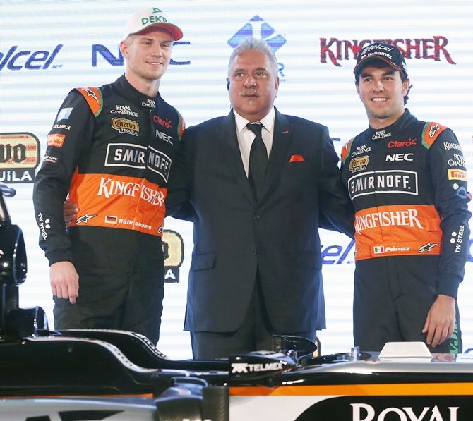 Force India Formula One drivers, Nico Hulkenberg of Germany, left, and Sergio Perez of Mexico,right, and Force India team principal Vijay Mallya pose with the new Force India racing car 
