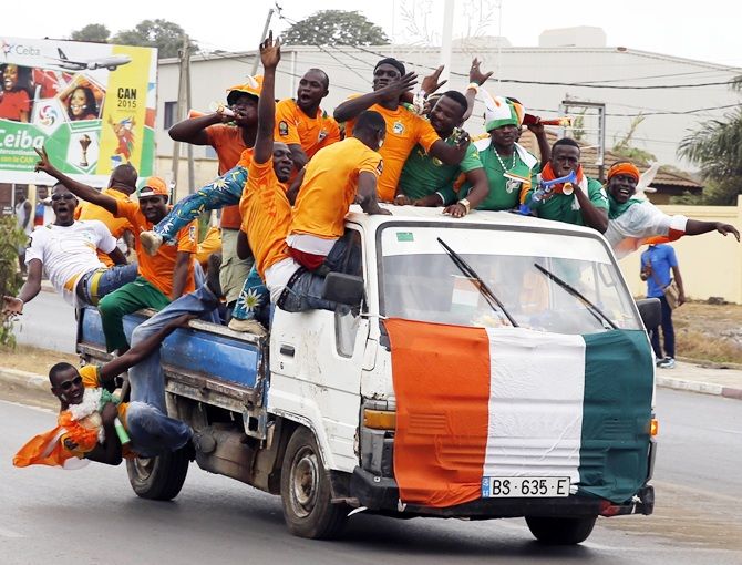 Fans of Ivory Coast cheer from a vehicle