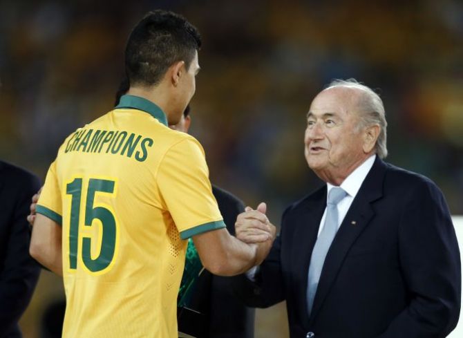 Australia's Massimo Luongo (L) shakes hands with FIFA President Sepp Blatter as he collects the Most Valuable Player award during the trophy presentation ceremony of the Asian Cup