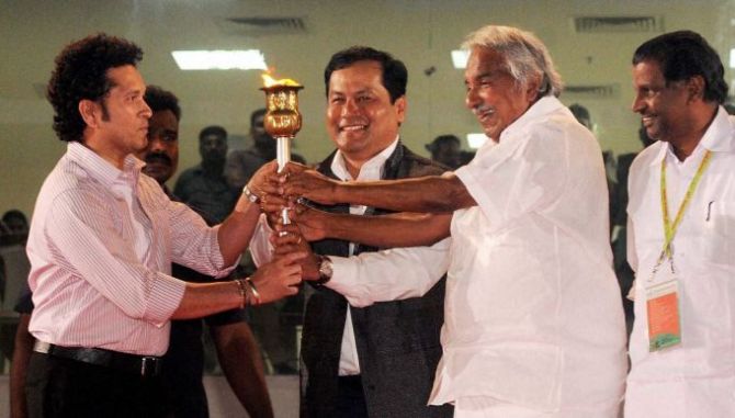 Union Sports Minister Sarbananda Sonowal, second from left, with Kerala Chief Minister Oommen Chandy and Sachin Tendulkar light the lamp to inaugurate the National Games. Photograph: PTI