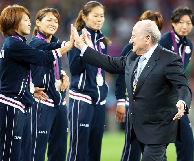 Sepp Blatter gives high fives to Aya Miyama of Japan