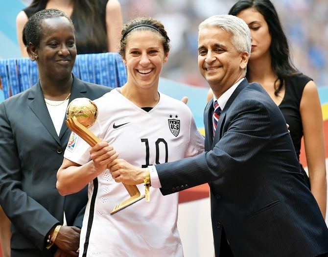 Sunil Gulati, the president of the United States Soccer Federation, poses for a picture   with Carli Lloyd after winning the Golden Ball trophy