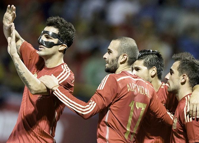 Spain's Cesc Fabregas, left, celebrates with teammates during an international friendly match 