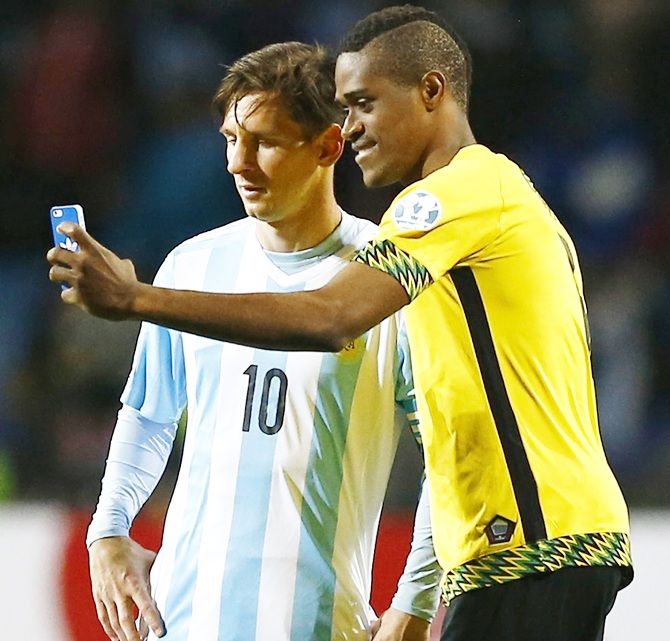 Jamaica's DeShorn Brown takes a selfie with Argentina's Lionel Messi.