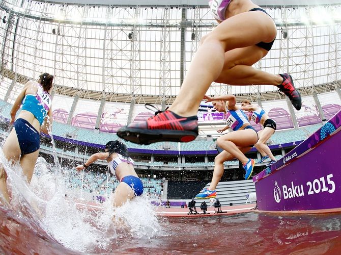 Competitors clear the water jump 