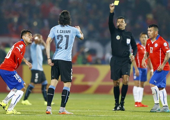  Referee Sandro Ricci shows a second yellow card to Uruguay's Edinson Cavani 