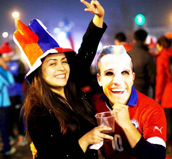 Chilean fans, one of whom wearing a mask of Chilean soccer player Alexis Sanchez