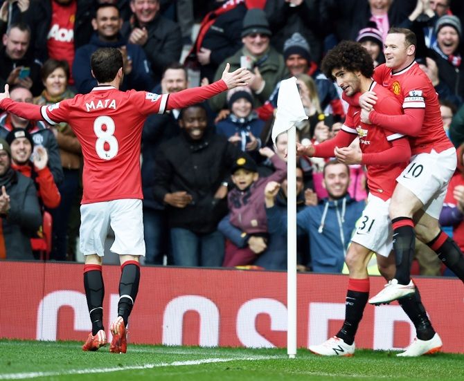  Marouane Fellaini, centre, of Manchester United is congratulated by teammates Juan Mata, left and Wayne Rooney after scoring the opening goal 