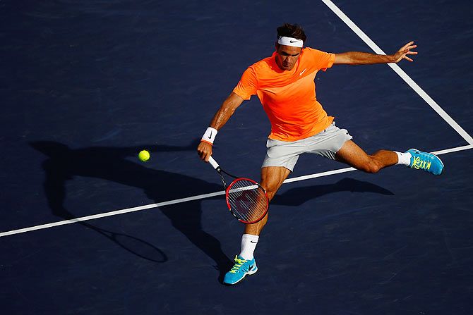 Roger Federer plays a return against Novak Djokovic