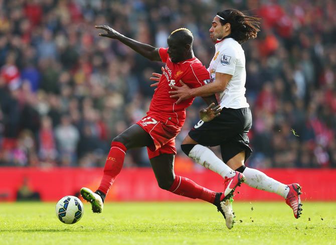 Mamadou Sakho of Liverpool is challenged by Radamel Falcao of Manchester United during the Barclays Premier League match
