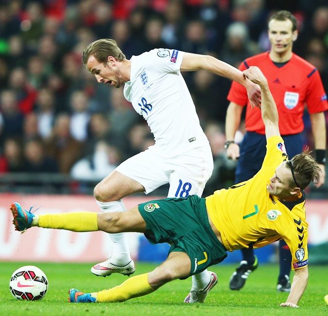 Harry Kane of England, left, is tackled by Arturas Zulpa of Lithuania