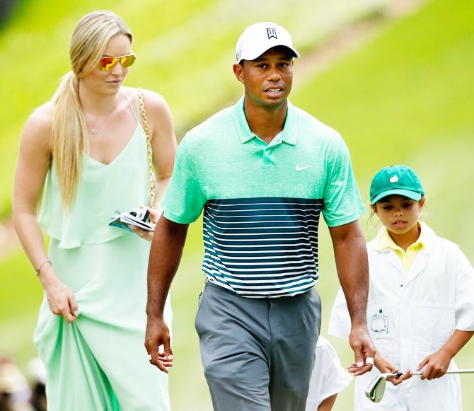 Tiger Woods of the United States walks with his Lindsey Vonn