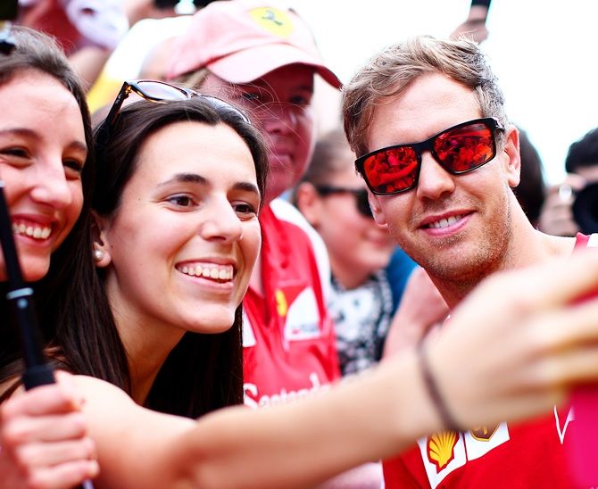 Sebastian Vettel of Germany and Ferrari poses for a photograph with fans