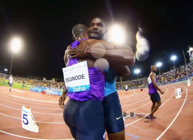Race winner Justin Gatlin of the United States embraces Femi Ogunode of Qatar