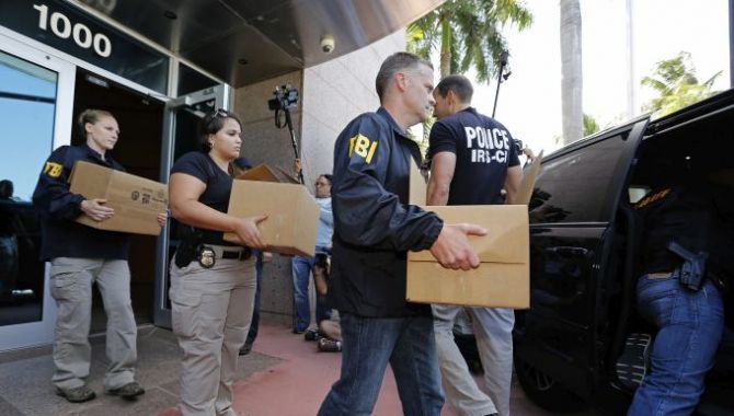 FBI agents carry boxes from the headquarters of CONCACAF 