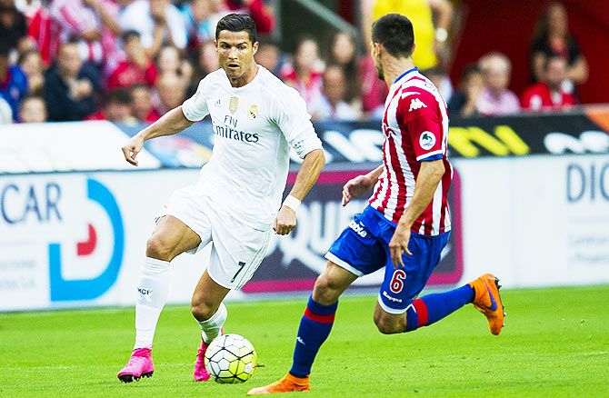 Real Madrid's Cristiano Ronaldo duels for the ball with Real Sporting de Gijon's Sergio Alvarez during a La Liga match