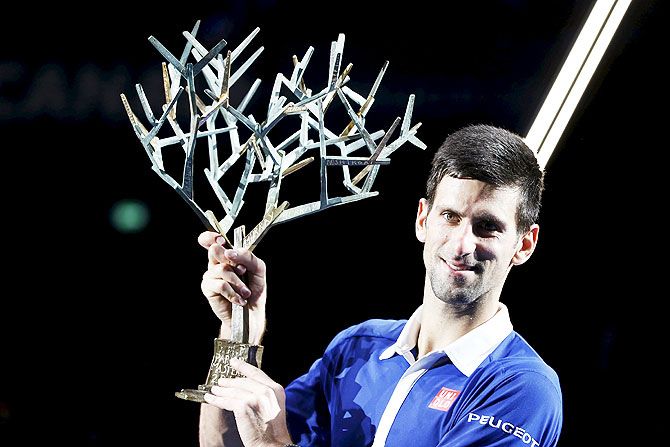 World number one Novak Djokovic of Serbia poses with the trophy after beating Britain's Andy Murray in their Paris Masters final on Sunday