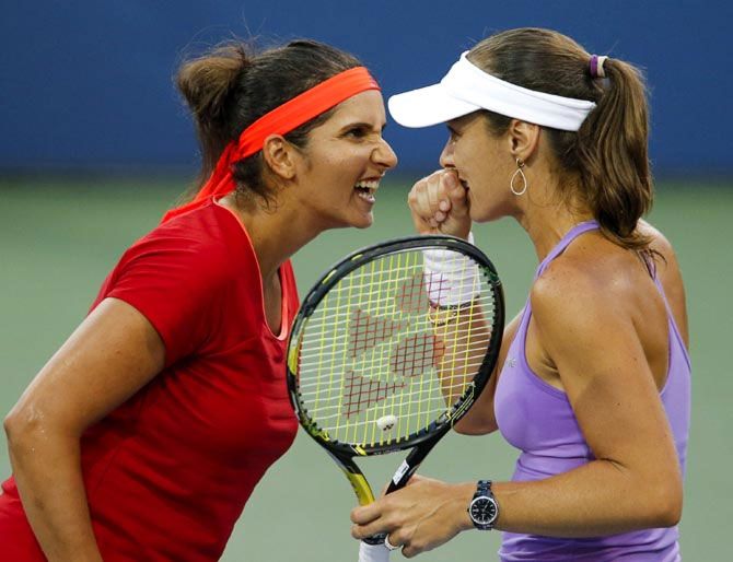 Sania Mirza (left) and Martina Hingis discuss strategy between points