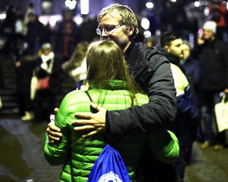 People comfort each other shortly after the match between Germany and the Netherlands was cancelled following a bomb alert at the HDI-Arena in Hanover on Tuesday