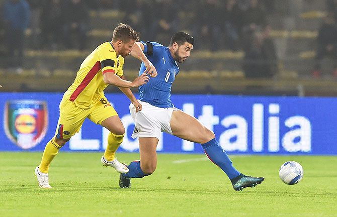Italy's Graziano Pelle (left) is challenged by a Romania player during their international friendly at Stadio Renato Dall'Ara in Bologna on Tuesday
