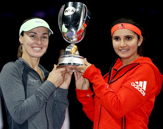 India's Sania Mirza, right, and Switzerland's Martina Hingis hold up the Martina Navratilova Doubles Trophy 