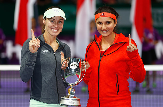 Martina Hingis of Switzerland and Sania Mirza of India hold up the Martina Navratilova Doubles Trophy 
