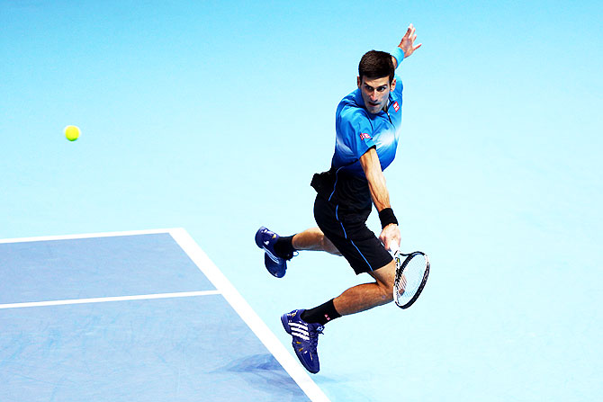 Novak Djokovic volleys during the men's singles final against Roger Federer