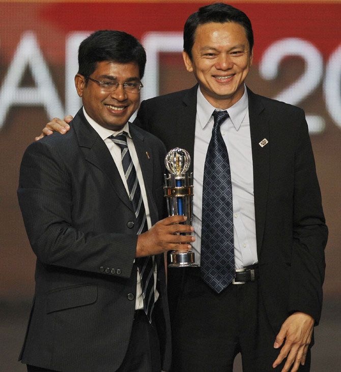 Bangladesh Football Federation representative, left receives the aspiring member association of the year during the AFC annual awards