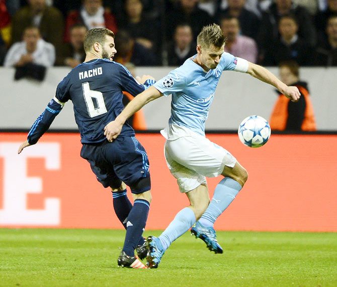 Real Madrid's Nacho (left) wins the ball in a challenge against Malmo FF's Markus Rosenberg