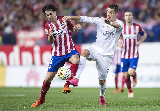 Real Madrid's Cristiano Ronaldo (right) competes for the ball with Atletico de Madrid's Tiago Mendes
