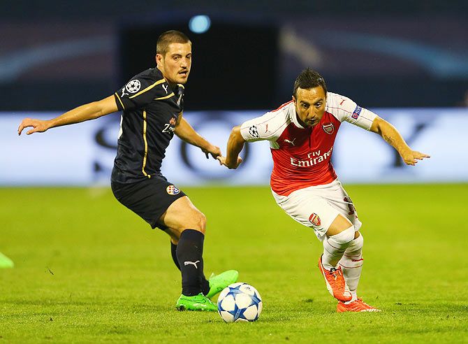 Arsenal's Santi Cazorla goes past Dinamo Zagreb Arijan Ademi (right) during their UEFA Champions League Group F match at Maksimir Stadium in Zagreb on September 16