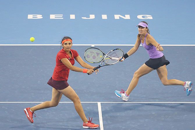 Martina Hingis and Sania Mirza return the ball during their doubles match against Flavia Pennetta and Sara Errani during their China Open pre-quarterfinal match at the National Tennis Centre in Beijing on Wednesday