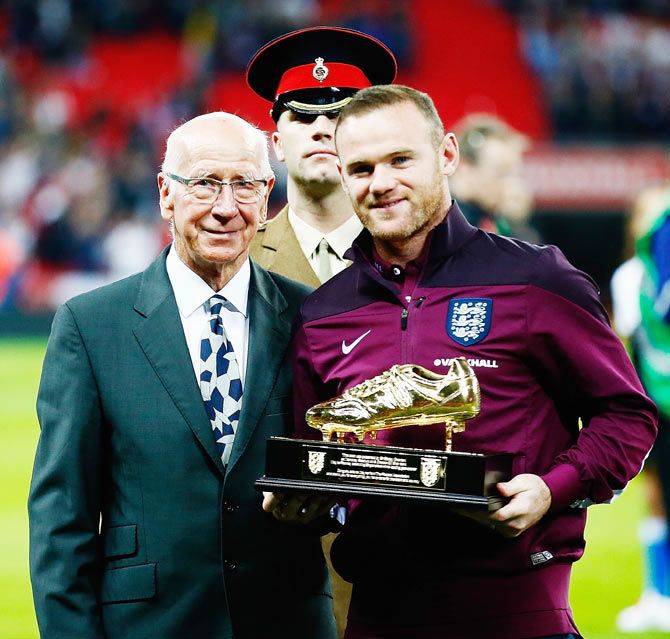 England's Wayne Rooney is presented with the Golden Boot by Sir Bobby Charlton for breaking his 49 goal-record