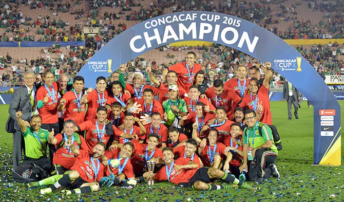 Mexico players pose with trophy after defeating the United States 3-2 in overtime in CONCACAF Cup match at Rose Bowl 