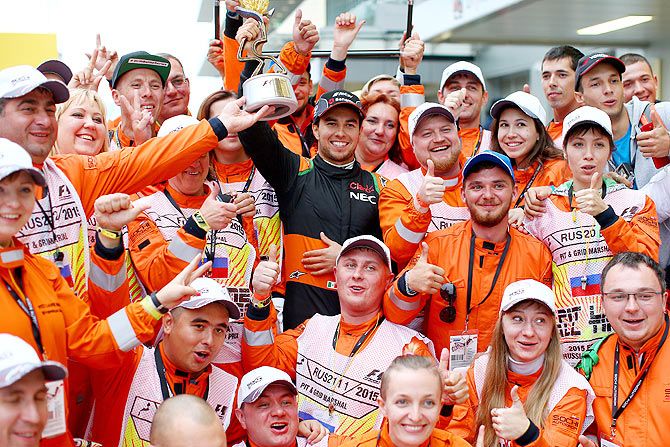 Force India's Mexican driver Sergio Perez celebrates with course marshalls after finishing third at the Russian Formula One Grand Prix