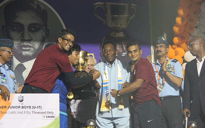 Pele hands over the Subroto Cup trophy to AIFF Academy colts at the Ambedkar Stadium 