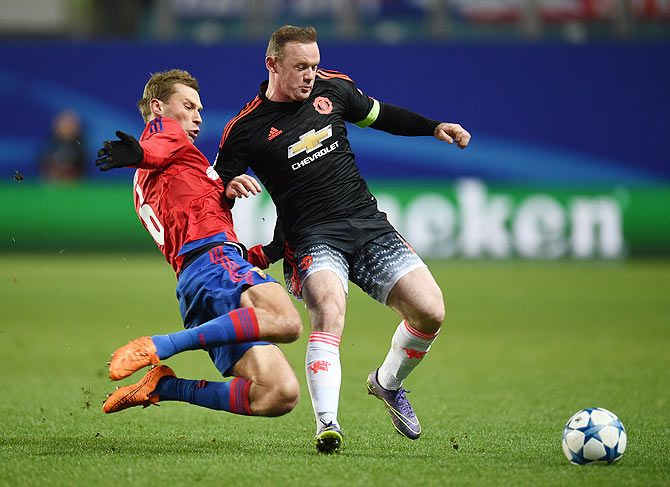 CSKA Moscow's Aleksei Berezutski (left) in action against Manchester United's Wayne Rooney during their UEFA Champions League Group B match at the Arena Khimki Stadium in Moscow, on Wednesday