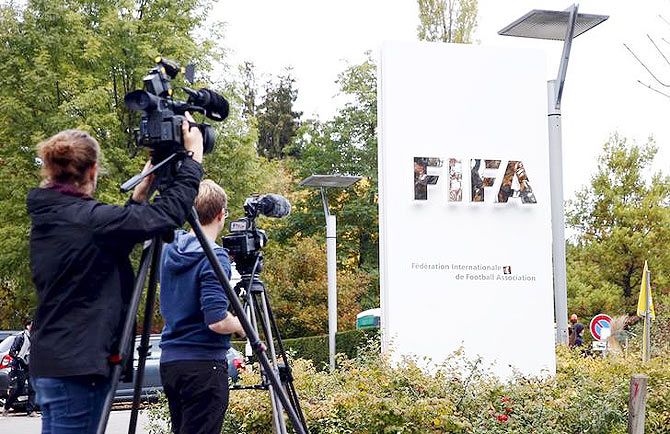 Members of the media film the FIFA logo outside their headquarters in Zurich 