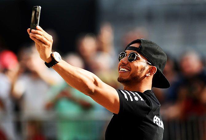 Lewis Hamilton of Great Britain and Mercedes GP takes a selfie in the pit lane after an autograph session during previews to the United States Formula One Grand Prix at Circuit of The Americas in Austin on Thursday