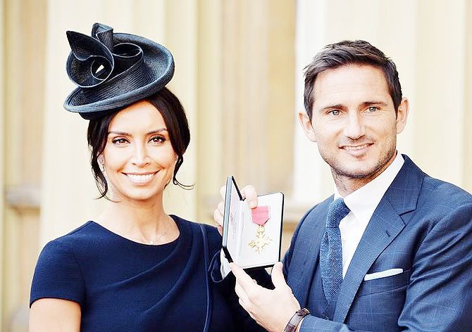 British football player Frank Lampard stands with his partner and television presenter Christine Bleakley as he holds his Officer of Order of the British Empire (OBE) medal, after it was presented to him by Prince William, at an Investiture ceremony at Buckingham Palace in London on Tuesday