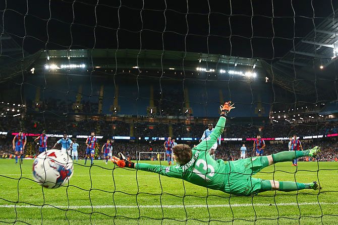 Crystal Palace's goalkeeper Wayne Hennessey is beaten by a penalty shot by Manchester City's Yaya Toure during their League Cup match at the Etihad Stadium in Manchester