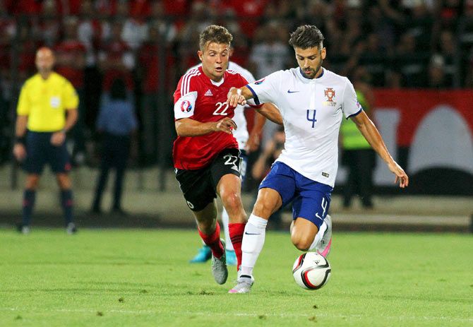 Albania's Amir Abrashi (left) challenges Portugal's Miguel Veloso as they vie for possession during their Euro 2016 qualifying match at Elbasan Arena stadium in Elbasan, Albania, on Monday