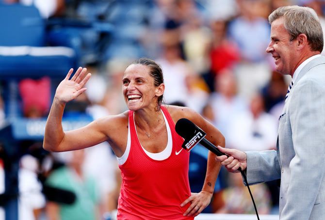 Roberta Vinci of Italy waves to her box during an on-court interview after defeating Serena Williams in their US Open semi-finals at the USTA Billie Jean King National Tennis Center at Flushing Meadows on Friday