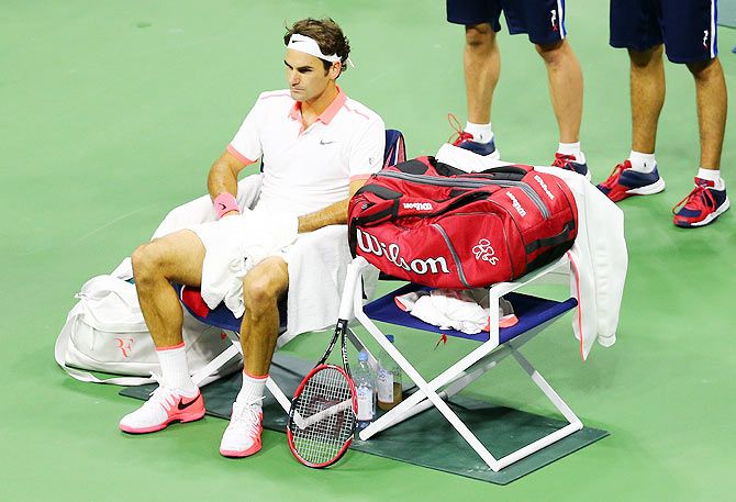 Roger Federer looks on from the sidelines