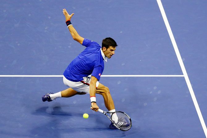 Novak Djokovic Serbia returns a backhand shot to Roger Federer