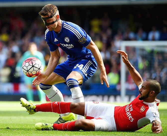 Chelsea's Gary Cahill is challenged by Arsenal's Theo Walcott
