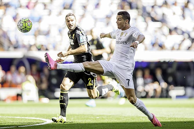 Real Madrid's Cristiano Ronaldo (right) beats Granada CF's David Rodriguez Lomban to the ball
