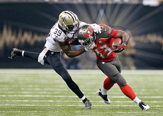 Tampa Bay Buccaneers running back Bobby Rainey (43) is tackled by New Orleans Saints cornerback Brandon Browner (39) in the second quarter at the Mercedes-Benz Superdome in New Orleans on Sunday, September 20