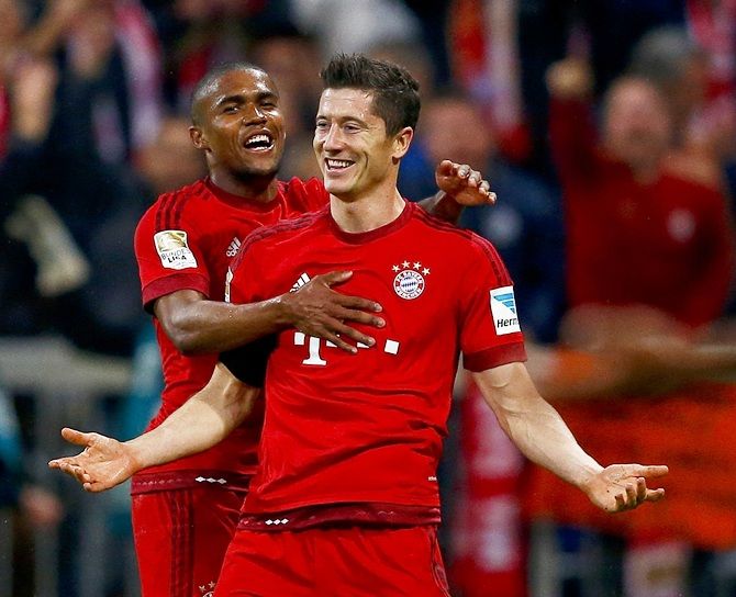 Bayern Munich's Robert Lewandowski, right, celebrates with teammate Douglas Costa